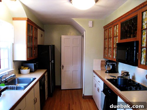 Grasscloth & Paint: A Fresh Take on Cabinet Updates 3 Second before photo of the kitchen, highlighting the original cabinetry and layout.