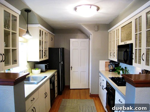 Grasscloth & Paint: A Fresh Take on Cabinet Updates 4 After kitchen photo featuring newly painted white cabinets, new hardware, and a modern pendant light.