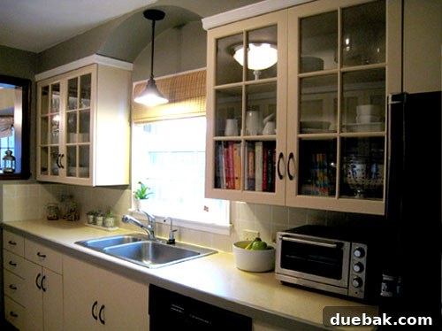 Grasscloth & Paint: A Fresh Take on Cabinet Updates 7 Full view of the renovated kitchen with all new elements like the rug, paint, and accessories.