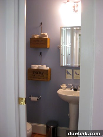 Bright & Beautiful Homes 11 Charming half bathroom featuring creative storage solutions with vintage boxes hung on the wall, neatly organizing toilet paper and towels, adding a unique and functional touch.