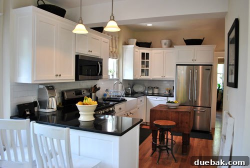 Bright & Beautiful Homes 7 Stunning open-concept kitchen with crisp white cabinets, sleek black granite countertops, modern fixtures, and ample natural light, showing a perfect blend of elegance and functionality.