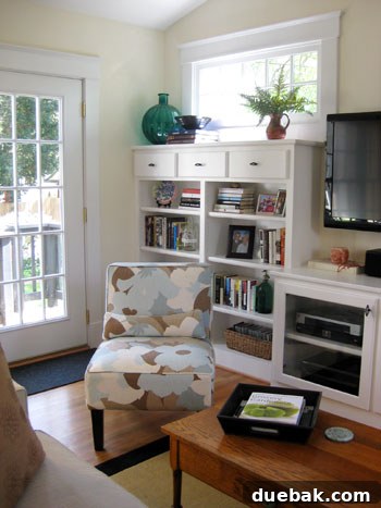 Bright & Beautiful Homes 10 Functional and stylish family room featuring a wall of built-in cabinetry for books and storage, a flat-screen TV, and a chic slipper chair, blending comfort with smart design.