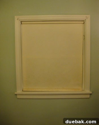 Old, yellowed roller shade before removal