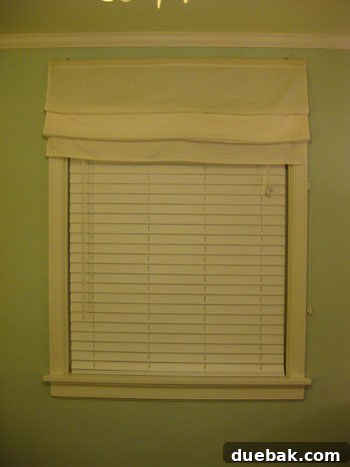 Layered window treatment with faux wood blinds and Roman shade
