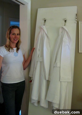 Stylist Cat showcasing perfectly ironed robes next to a removed bathroom door