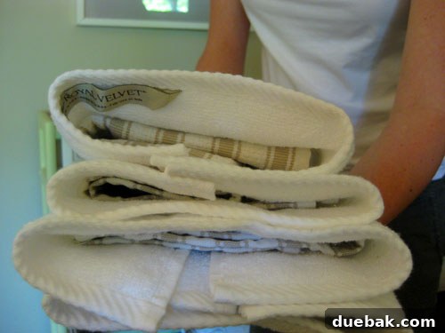 Stylist showing how to stuff towels with dishcloths for a fuller look