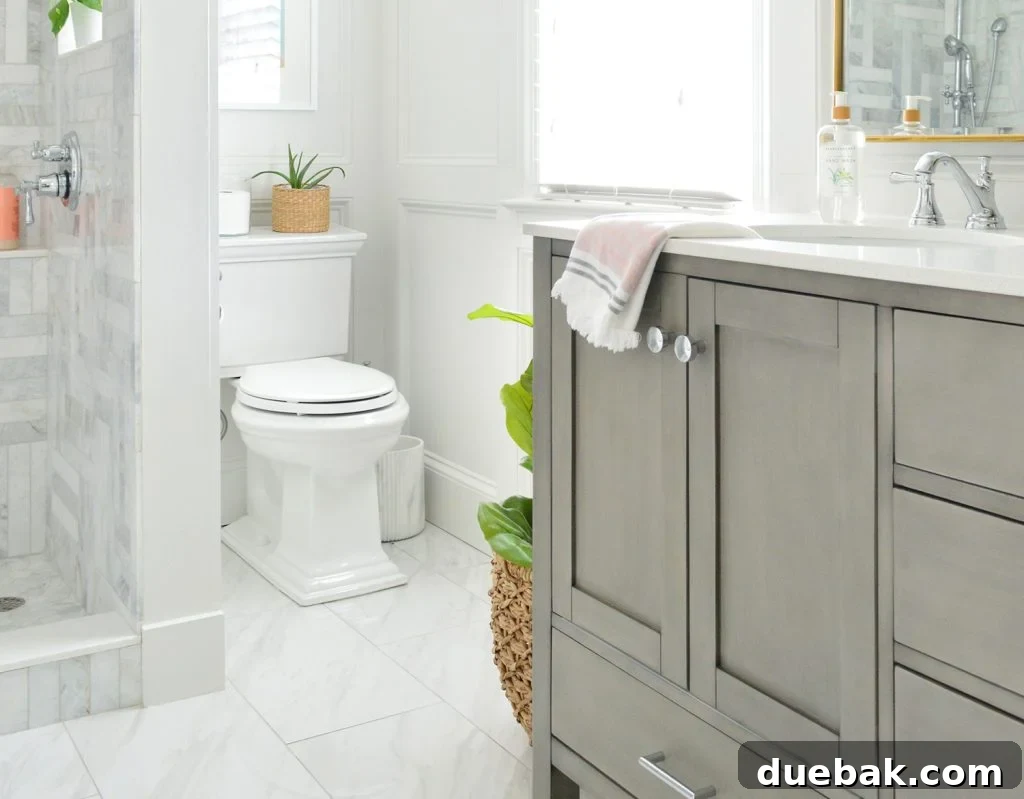 Upgrade Your Toilet with a Dual-Flush Kit 11 A luxurious Kohler Memoirs Toilet in a beautifully designed marble bathroom with elegant wall molding, showcasing a high-end bathroom aesthetic.