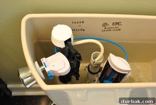 Upgrade Your Toilet with a Dual-Flush Kit 9 Internal view of a toilet tank with a dual flush conversion kit fully installed, showing connections.