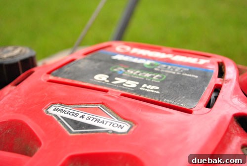 Old, well-used Troy-Bilt lawn mower sitting in the yard