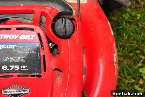 Close-up of a neglected lawn mower engine, showing dirt