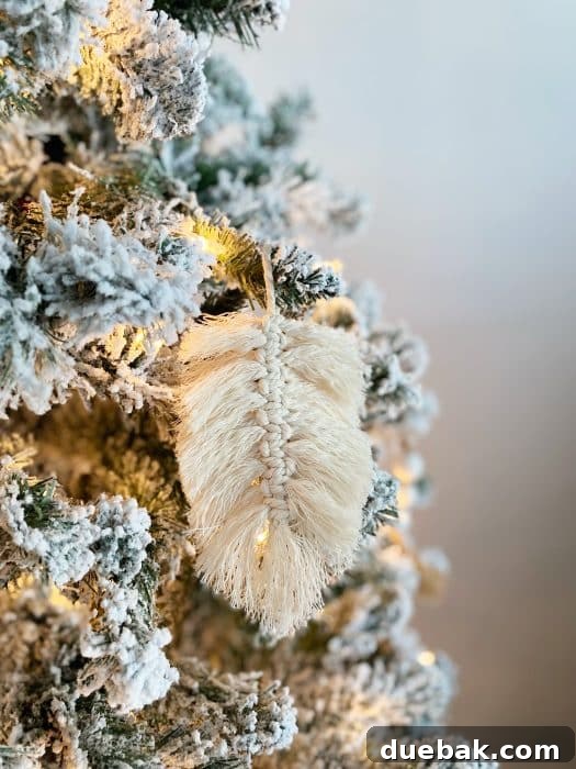 A finished macrame feather resting on a wooden surface, showcasing its perfectly trimmed and shaped form.