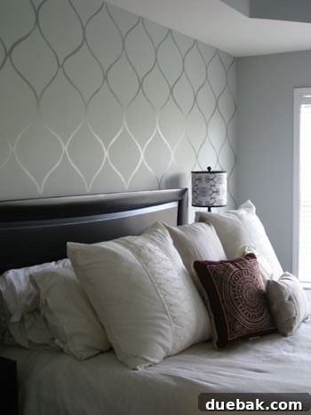 Creating a Faux Wallpaper Silver Wall Stencil 3 The room after a stunning paint transformation, featuring a wall with a sophisticated, custom-stenciled tone-on-tone pattern, resembling high-end wallpaper.