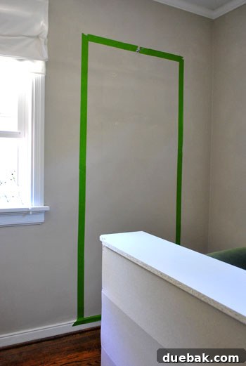 Wall taped off behind where the bookcase will sit, ready for paint