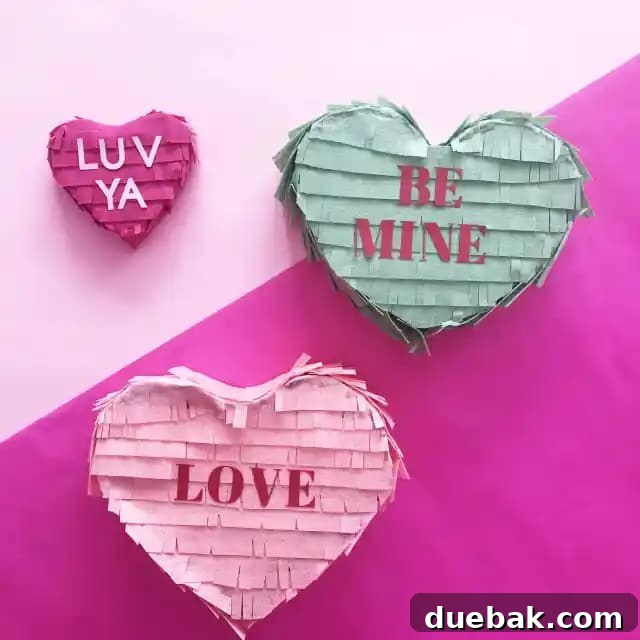 DIY Conversation Heart Pinata made from felt, cardboard, and tape, shown with a child's hand reaching for it