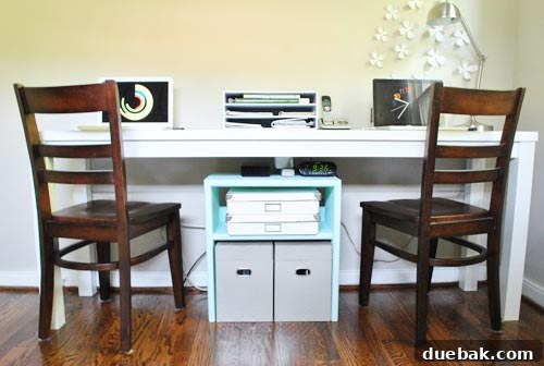 A wide shot of the organized home office desk with the custom storage unit and desktop organizer in place, showing two distinct workspaces.