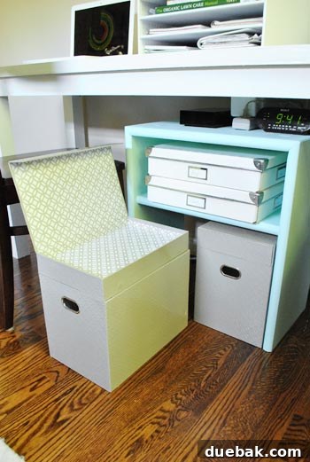 Close-up of the gray file box with its top compartment open, revealing space for small office supplies.