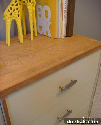 Close-up of the two-tone dresser showcasing the natural wood grain and new hardware detail, possibly with decorative items like giraffes.