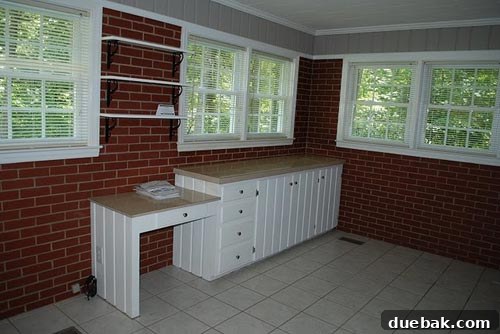 Dark and gloomy laundry room with red brick walls before renovation