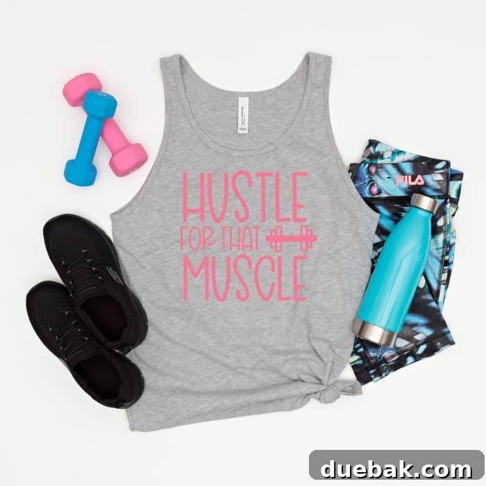 Essential Workout SVG Files for Cricut Users 11 An athletic grey tank top featuring the 'Hustle For That Muscle' slogan in vibrant pink text, accessorized with pink and blue workout items, inspiring motivation for gym sessions.