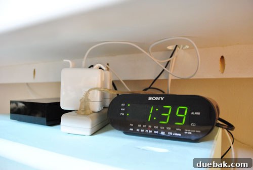 Untangle Your Tech Cables 4 Close-up of a desk shelf cluttered with a power strip and devices