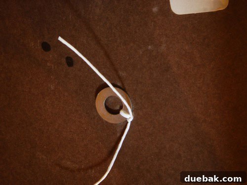 Handcraft Your Perfect Ottoman 11 Underside of ottoman showing thread tied with a washer