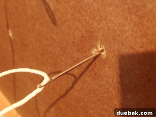 Handcraft Your Perfect Ottoman 8 Large upholstery needle threaded with heavy-duty thread
