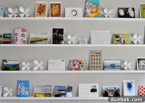 Craft Your Own Stylish Wall Shelves 16 Variety of postcards and small prints on the DIY art ledges, showcasing the evolving display