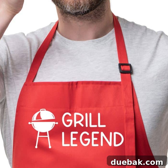 BBQ King Father's Day SVG 8 A man wearing a red apron with the 'Grill Legend' design, showing off a custom Father's Day gift idea.