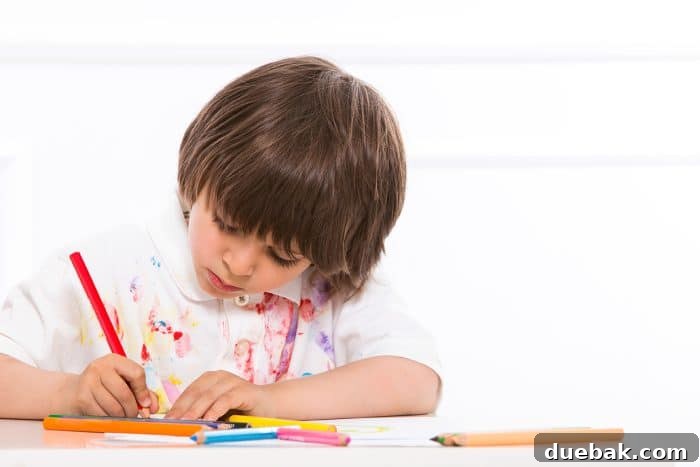 A young boy with pencils and paper, ready to play a pen and paper game, smiling at the camera.
