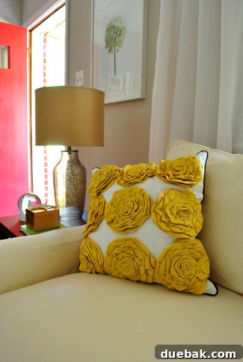 A close-up of a yellow ruffled throw pillow, highlighting the intricate ruffles and the soft texture, likely displayed on a piece of furniture.