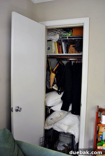 Clever Closet Shelf for Built-In Dog Crate 3 Another 'before' image showing an even more cluttered closet with a dog crate and a pile of linens