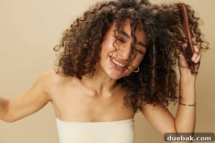 Person applying curl cream to damp curly hair.