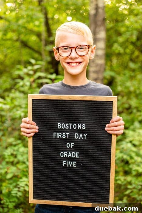 A joyful student posing with a unique first day of school photo prop, demonstrating different creative options.