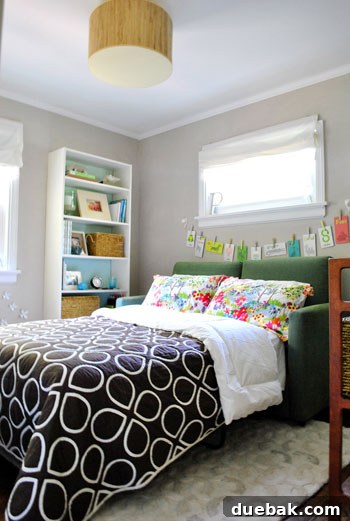 Smart Space: Office & Guest Quarters 2 Full-sized sofa bed folded out and dressed for company, featuring comfortable linens and pillows.