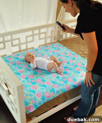 Clara's weekly milestone photo setup with a patterned fabric background and soft lighting