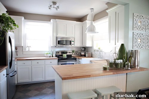 The Thousand Dollar Kitchen That Looks Like a Million 3 After kitchen view showcasing newly painted white cabinets, warm oak countertops, and modern stainless steel appliances.