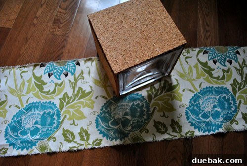 Transform Cork Into Chic Fabric Vases 7 Fabric strip with excess material for hemming, ready to be wrapped around a DIY cork vase for a patterned finish.