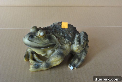 A ceramic frog sculpture, before being painted, showing its original 'wart-riddled' and somewhat unsightly texture.
