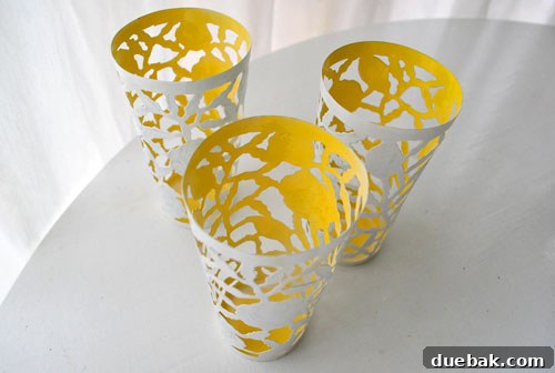 A beautifully spray-painted metal cup, showing a clean, crisp line between its vibrant yellow interior and pristine white exterior. The transformation is complete.