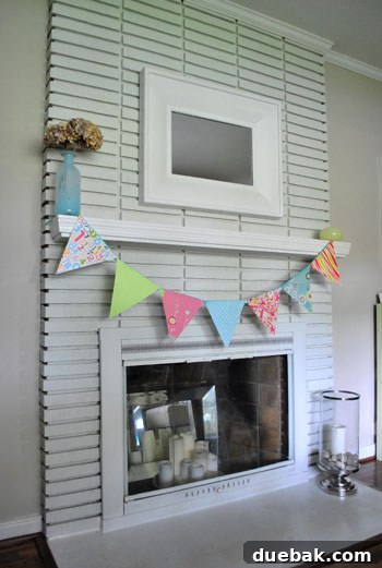 A cheerful, handmade banner placed over the living room fireplace, adding a vibrant pop of color and personality.