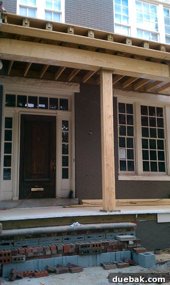 Close-up view of restoration work on historic architectural details of a home exterior.
