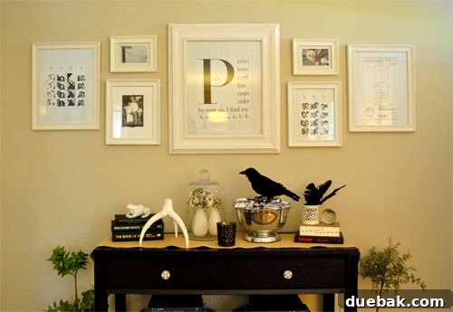 A console table decorated for Halloween with a creepy raven, books, and candles.