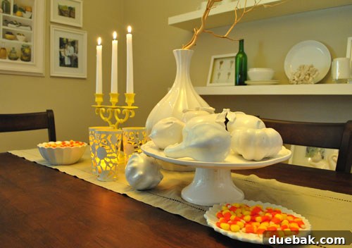 Close-up of a dining table centerpiece with votive cups, faux candles, and a manzanita branch.