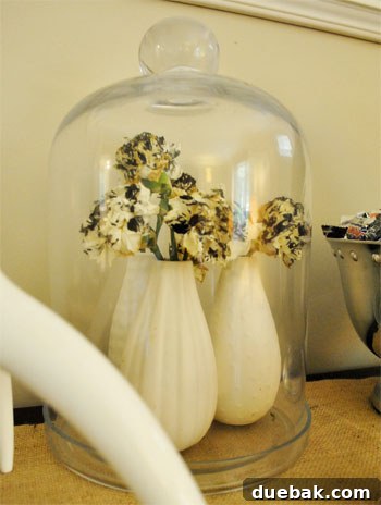 Close-up of black painted carnations under a glass dome for Halloween decoration.