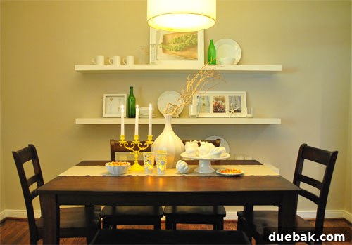 Close-up of a dining table with candy corn, faux gourds, and a yellow spray-painted candlestick.