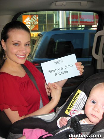 Couple posing with a green room placard in front of Home Depot