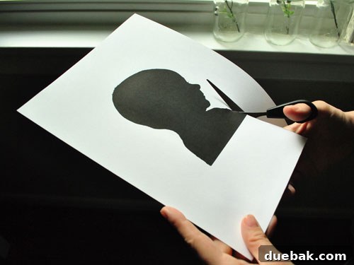Sherry Petersik carefully cutting out the baby silhouette with small scissors