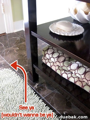 Bathroom after rug removal, showcasing marble tile