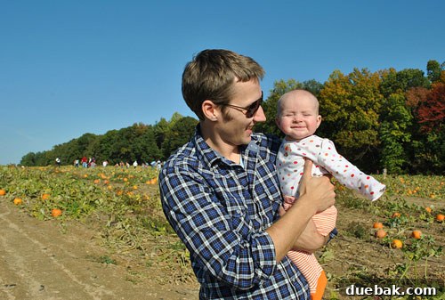 Clara at the pumpkin patch, arms outstretched joyfully