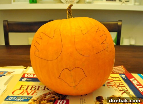 Pumpkin design sketch with handprint eyes, lips, and hairline